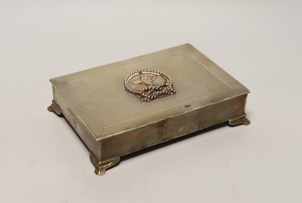 An Elizabeth II engine turned silver rectangular cigarette box, with yellow metal applique and interior inscription relating to the Hong Kong Rope Manufacturing Co, 17.4cm.